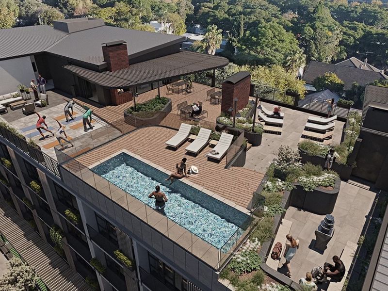An elevated rooftop terrace featuring a swimming pool, glass balustrades, timber decking, and landscaped planters with views over the surrounding area.