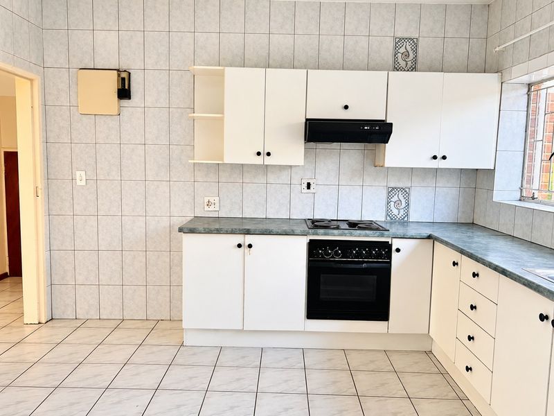 A functional kitchen featuring white cabinetry, a built-in oven and hob, tiled walls, and tiled flooring, offering a blank canvas for modern updates.