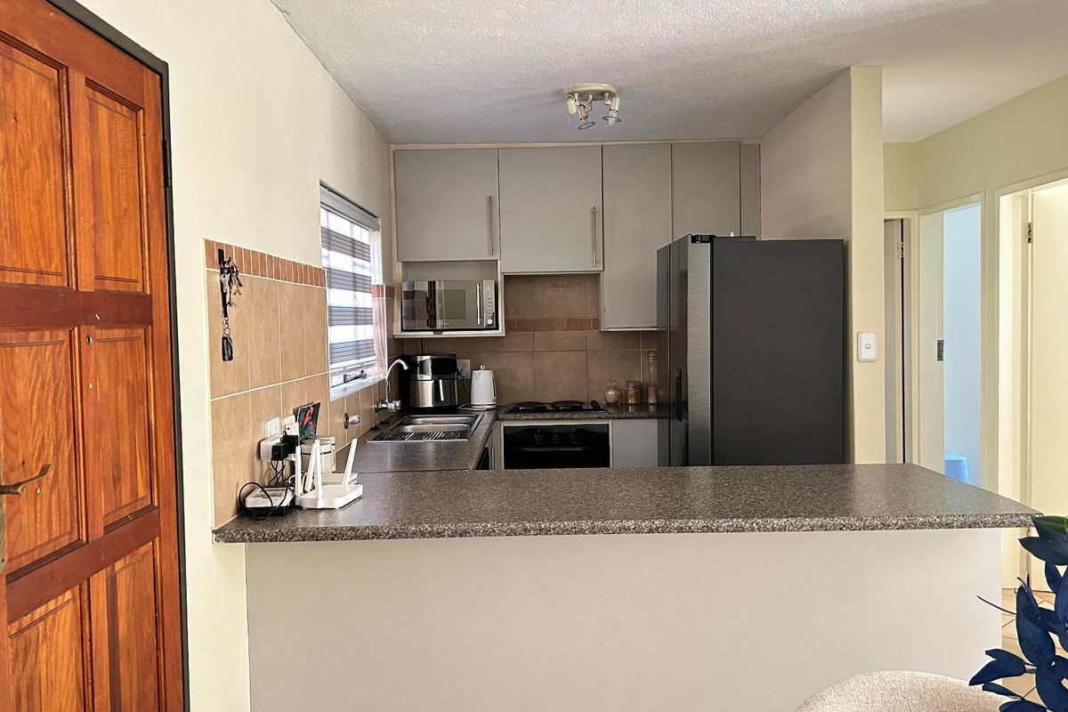 A functional kitchen featuring built-in cabinetry, a breakfast bar, and integrated appliances, providing a practical layout for daily cooking and meal preparation.