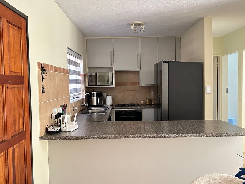 A functional kitchen featuring built-in cabinetry, a breakfast bar, and integrated appliances, providing a practical layout for daily cooking and meal preparation.