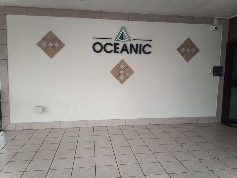 The entrance foyer of the Oceanic apartment building, featuring tiled flooring and prominent building signage.