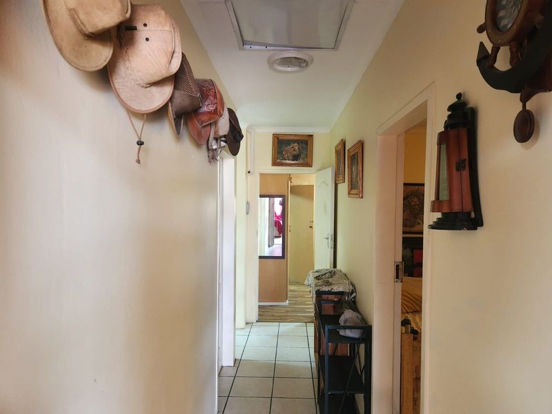 A functional residential hallway featuring tiled flooring and access to multiple rooms, providing a central circulation space within the home.