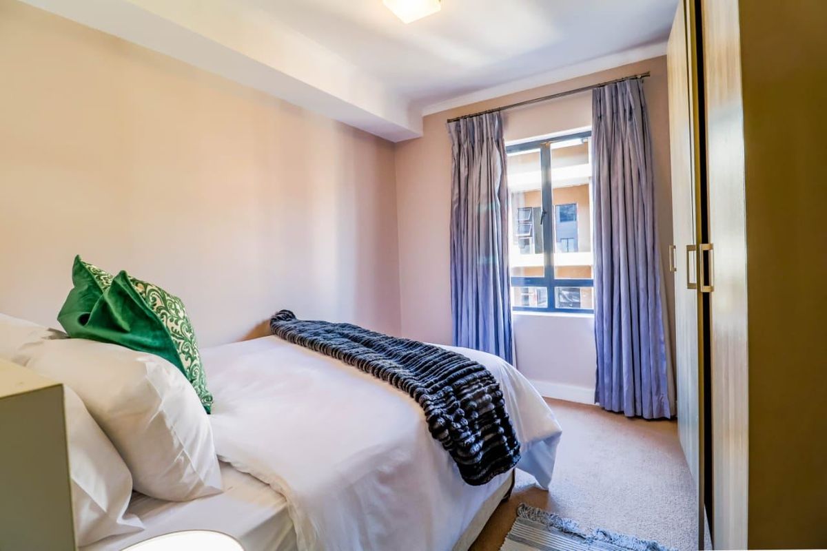 A well-maintained bedroom featuring neutral wall tones, carpeted flooring, and a built-in wardrobe, offering a comfortable and functional living space.