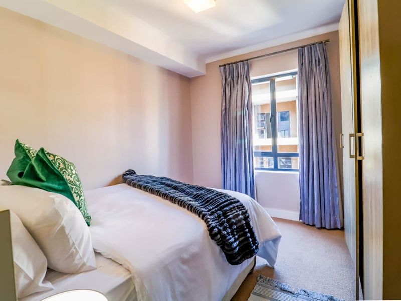 A well-maintained bedroom featuring neutral wall tones, carpeted flooring, and a built-in wardrobe, offering a comfortable and functional living space.