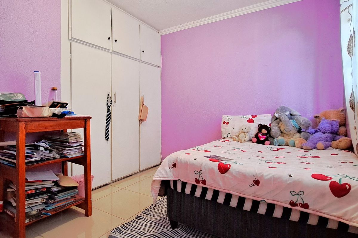 A bedroom featuring built-in cupboards, tiled flooring, and decorative cornice detailing.