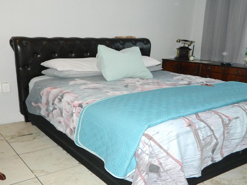 A bedroom featuring tiled flooring and neutral wall finishes, providing a functional space for rest.