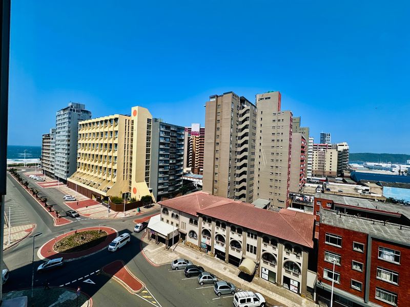 Elevated urban view overlooking the surrounding apartment buildings, street infrastructure, and coastal horizon.
