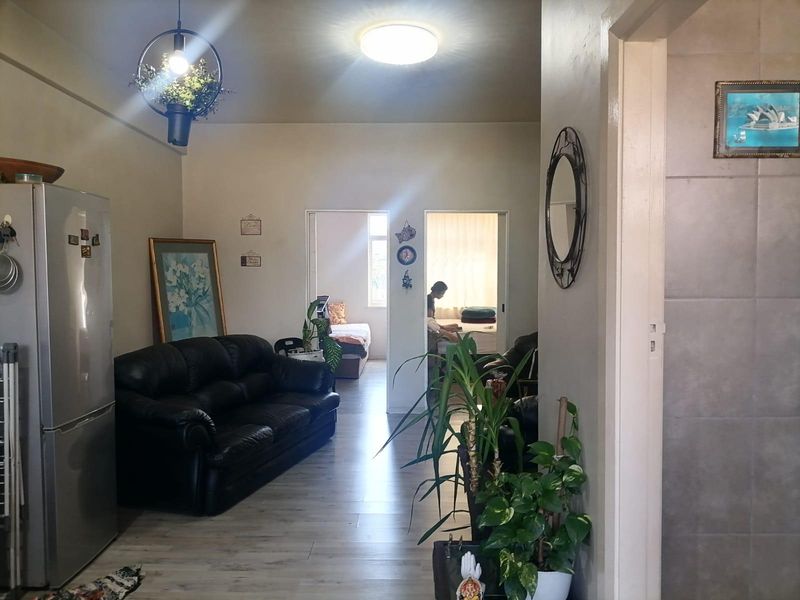 Open plan living area featuring laminate flooring and neutral walls, providing access to adjacent bedrooms.