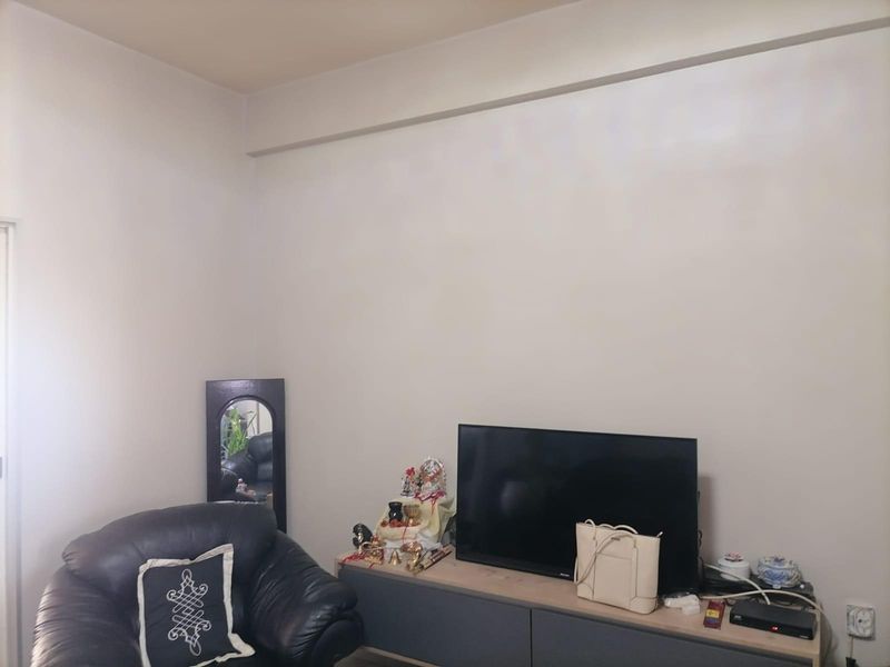 A simple living room area featuring neutral walls and a functional layout, suitable for various interior design styles.