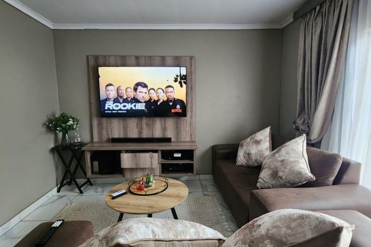 A comfortable living room featuring a built-in media console, tiled flooring, and neutral wall tones, creating a functional and inviting space.
