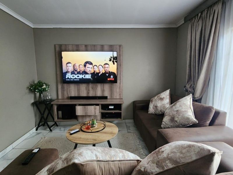 A comfortable living room featuring a built-in media console, tiled flooring, and neutral wall tones, creating a functional and inviting space.