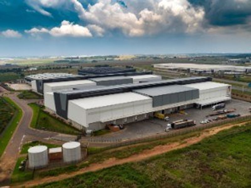 Aerial view of a large industrial warehouse facility featuring extensive loading bays, paved yard space, and on-site water storage tanks.