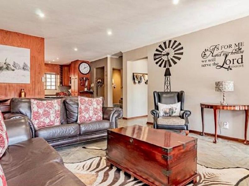 Open plan living area featuring tiled flooring and recessed lighting, with a view through to the kitchen area.
