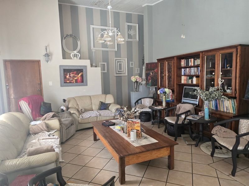 Spacious living room featuring tiled flooring, vaulted ceilings, and built-in wooden cabinetry, offering a comfortable and traditional living space.