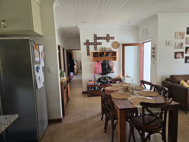 Open plan living and dining area featuring tiled flooring and a white tongue and groove ceiling with recessed lighting.