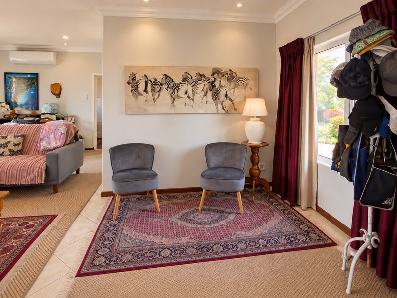 A well-maintained living area featuring tiled flooring, recessed downlighting, and a wall-mounted split-system air conditioning unit.
