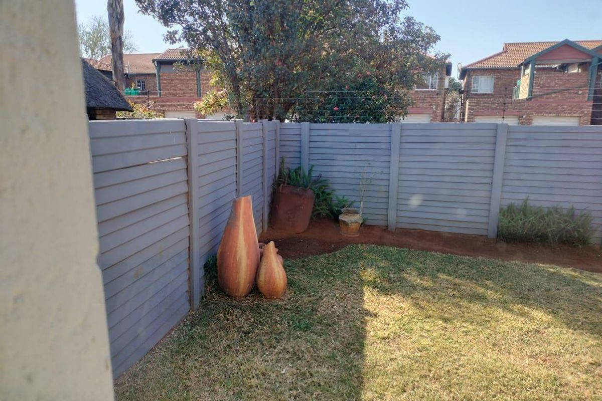 A private rear garden area featuring a well-maintained lawn and modern horizontal slat fencing, providing a secure and tidy outdoor space.
