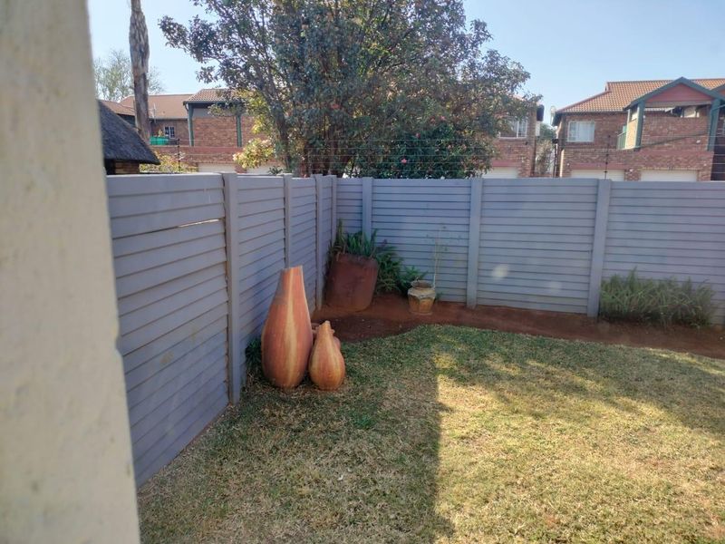 A private rear garden area featuring a well-maintained lawn and modern horizontal slat fencing, providing a secure and tidy outdoor space.