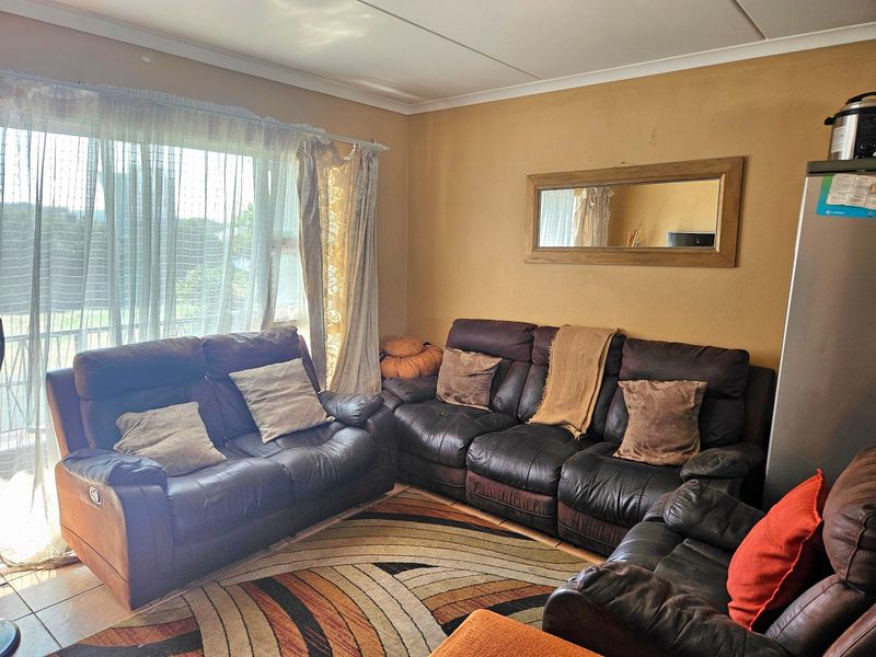 A comfortable living room featuring tiled flooring and a large sliding glass door that provides natural light and access to the exterior.