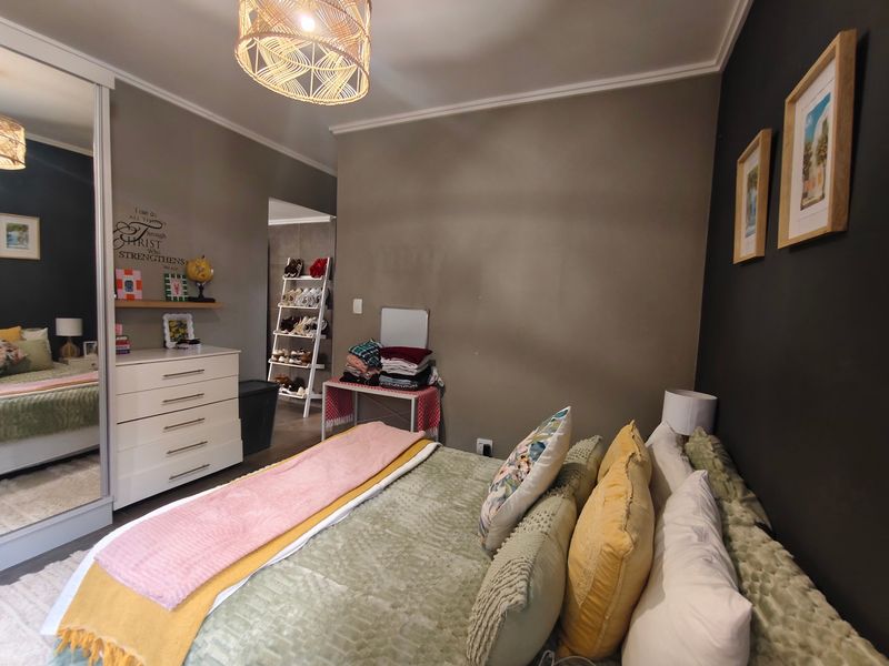 A well-maintained bedroom featuring a built-in wardrobe with mirrored sliding doors and decorative cove cornicing, offering a comfortable and functional living space.