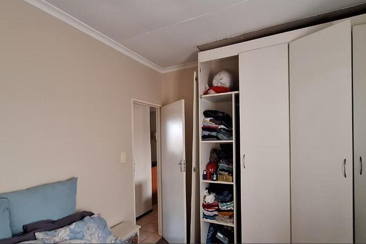 A bedroom featuring built-in cupboards with ample storage space and neutral wall finishes.