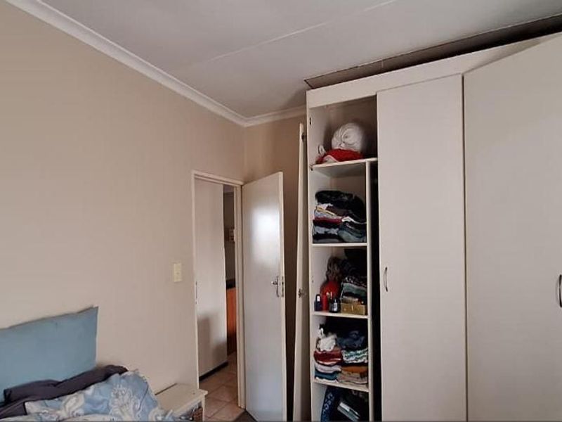 A bedroom featuring built-in cupboards with ample storage space and neutral wall finishes.