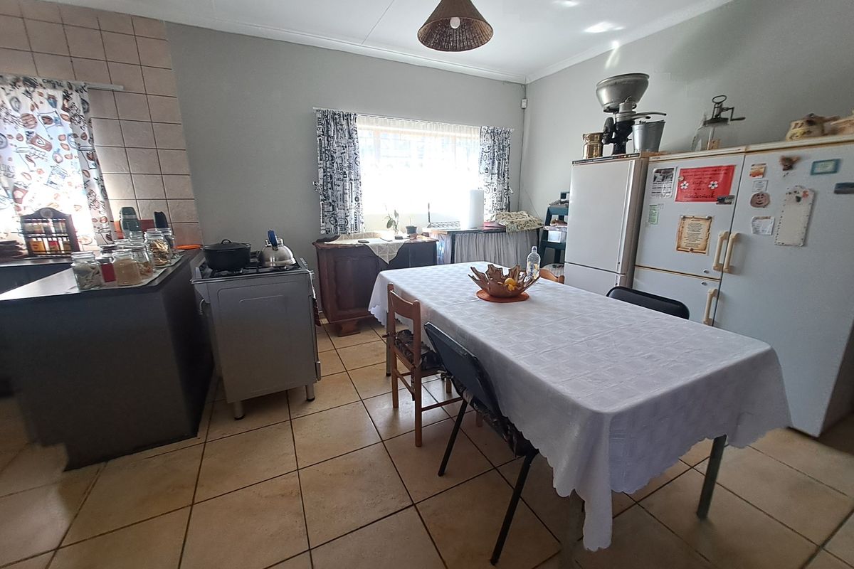 A functional kitchen area featuring tiled flooring, a tiled splashback, and a freestanding stove, offering a practical layout for daily meal preparation.