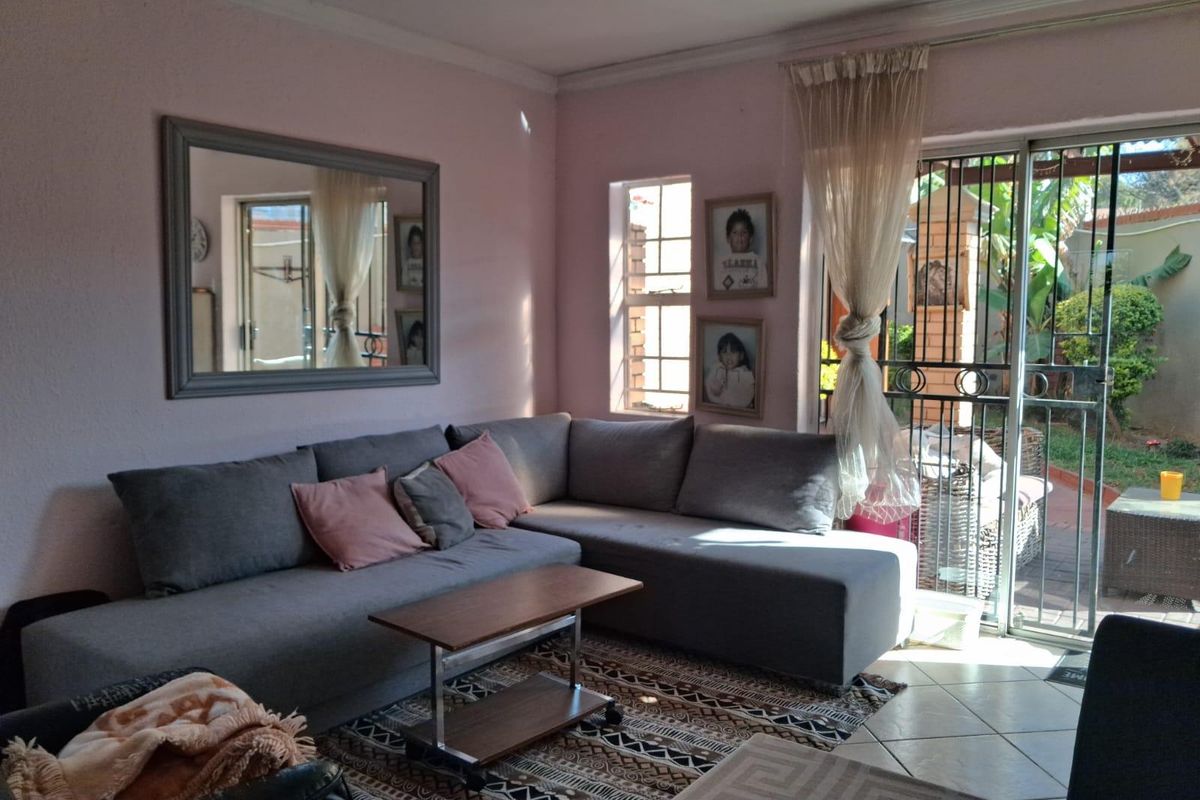 A comfortable living room featuring tiled flooring and a sliding glass door that provides direct access to the outdoor patio area.