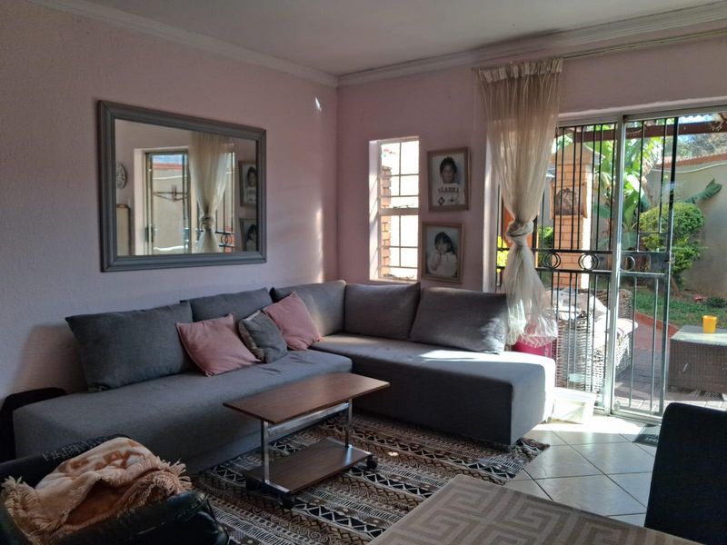 A comfortable living room featuring tiled flooring and a sliding glass door that provides direct access to the outdoor patio area.