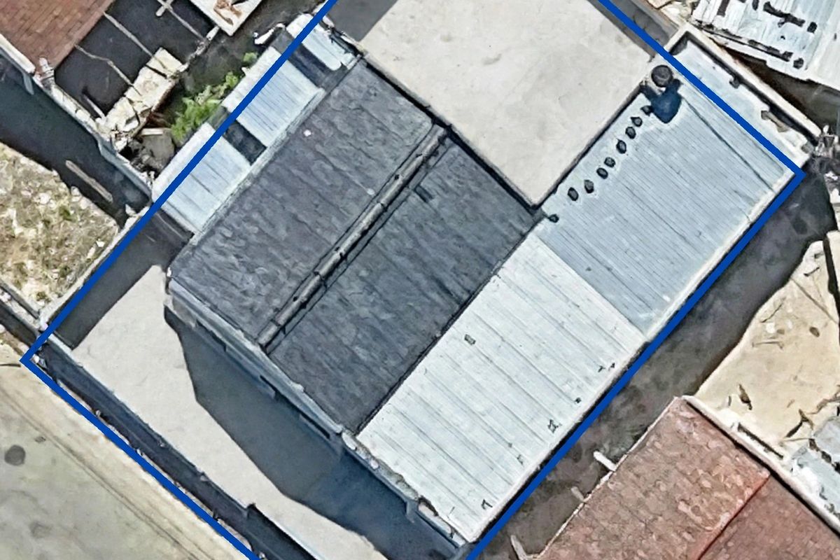 Aerial view of the property showing the roof structure, including sections of corrugated metal and flat roofing with visible vents.