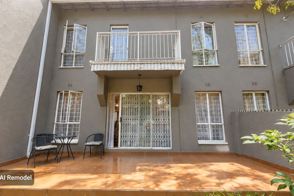 Rear view of the townhouse featuring a tiled patio, a first-floor balcony, and secure metal security gates and window bars.
