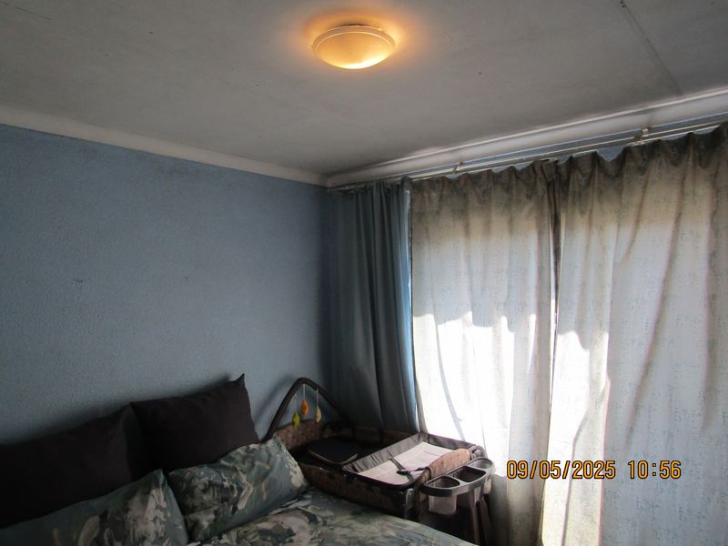 A bedroom featuring blue walls and a ceiling light fixture, requiring cosmetic updates to improve the overall condition and appeal of the space.