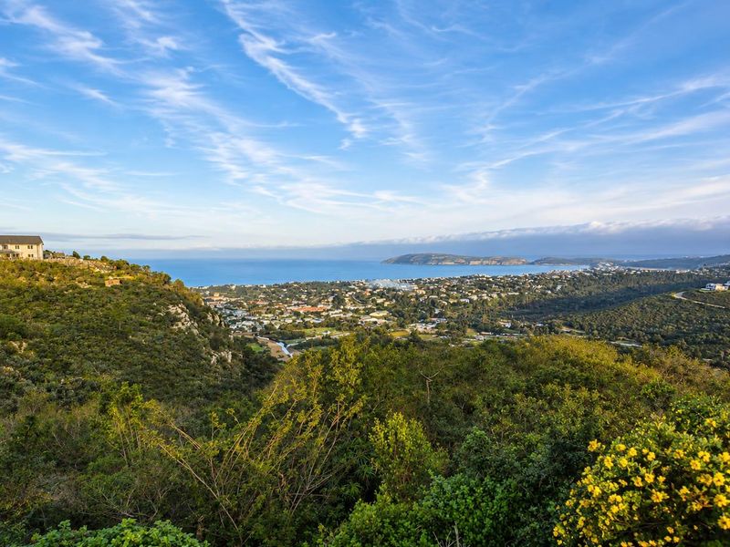 A panoramic elevated view overlooking the coastal town, surrounding hills, and the ocean horizon.