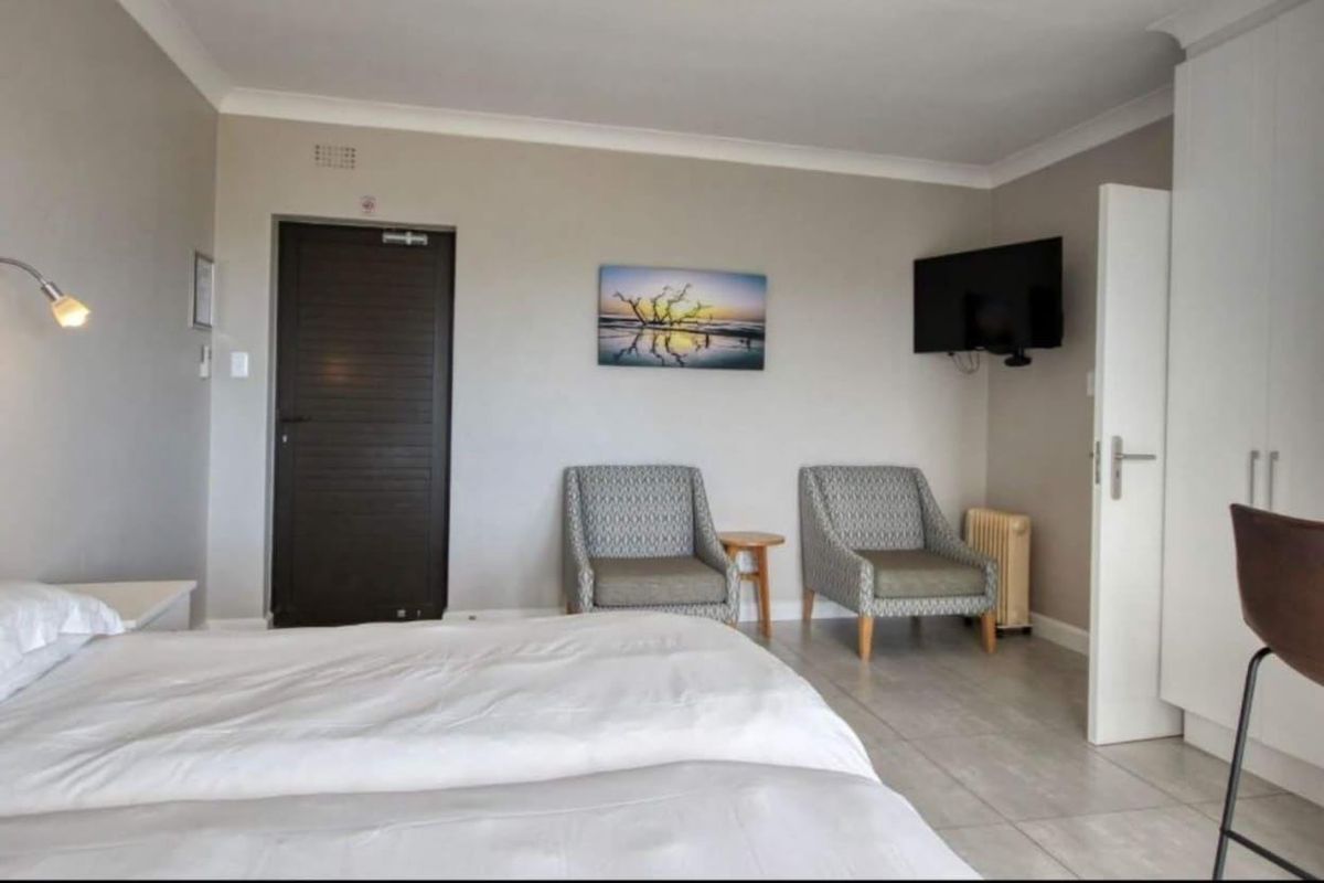 A well-maintained bedroom featuring tiled flooring, built-in wardrobe storage, and neutral wall finishes with cove cornicing.