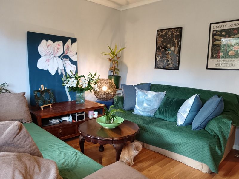 A cozy living room featuring warm hardwood flooring and classic coving, providing a comfortable and inviting space for relaxation.