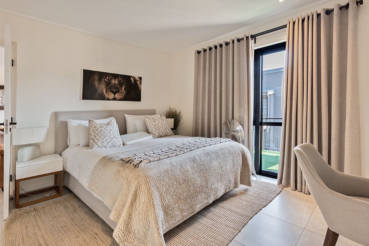 A well-maintained bedroom featuring tiled flooring, recessed lighting, and a sliding glass door providing access to an outdoor area.