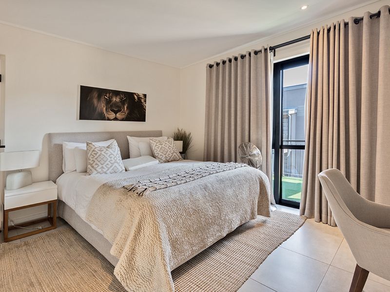 A well-maintained bedroom featuring tiled flooring, recessed lighting, and a sliding glass door providing access to an outdoor area.