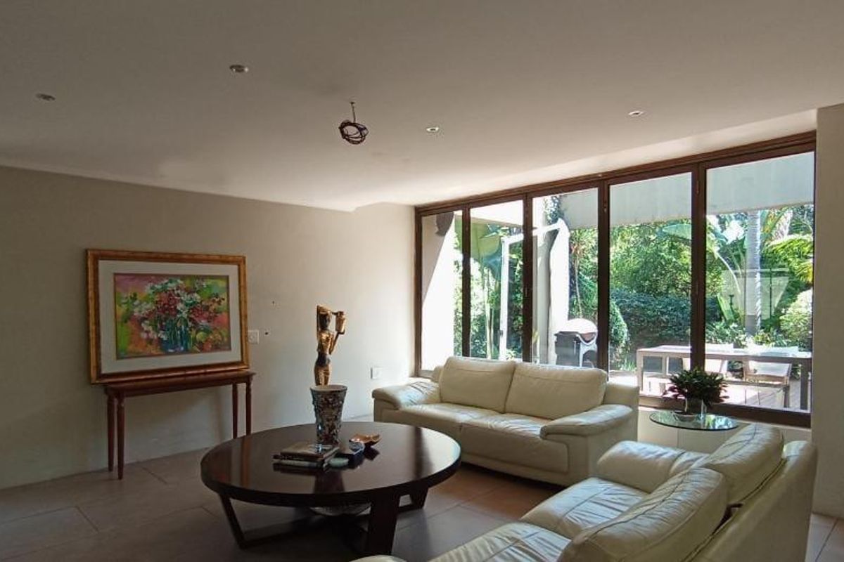 Spacious living room featuring large glass sliding doors that provide ample natural light and direct access to the garden area.
