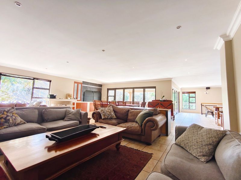 Spacious open-plan living area featuring tiled floors, recessed lighting, and a built-in fireplace, with large sliding doors providing ample natural light.