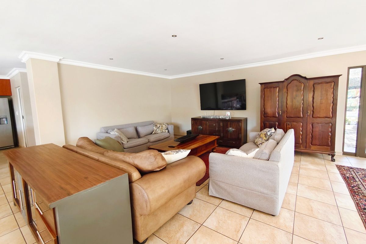 Spacious living room featuring neutral wall tones, tiled flooring, recessed lighting, and decorative cove cornicing, providing a comfortable and well-maintained area for relaxation.