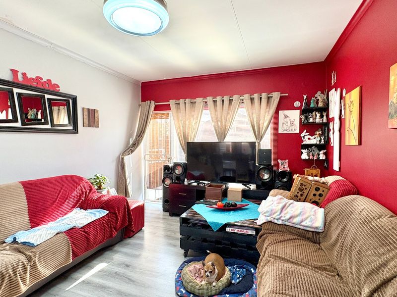 A living room featuring laminate flooring and a sliding glass door providing access to the exterior.