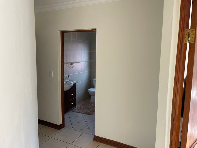 A view from a hallway looking into a bathroom featuring tiled floors and neutral wall finishes.
