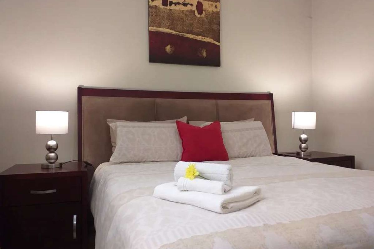 A standard bedroom featuring neutral wall tones and a central sleeping area.