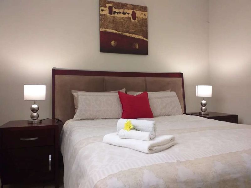 A standard bedroom featuring neutral wall tones and a central sleeping area.