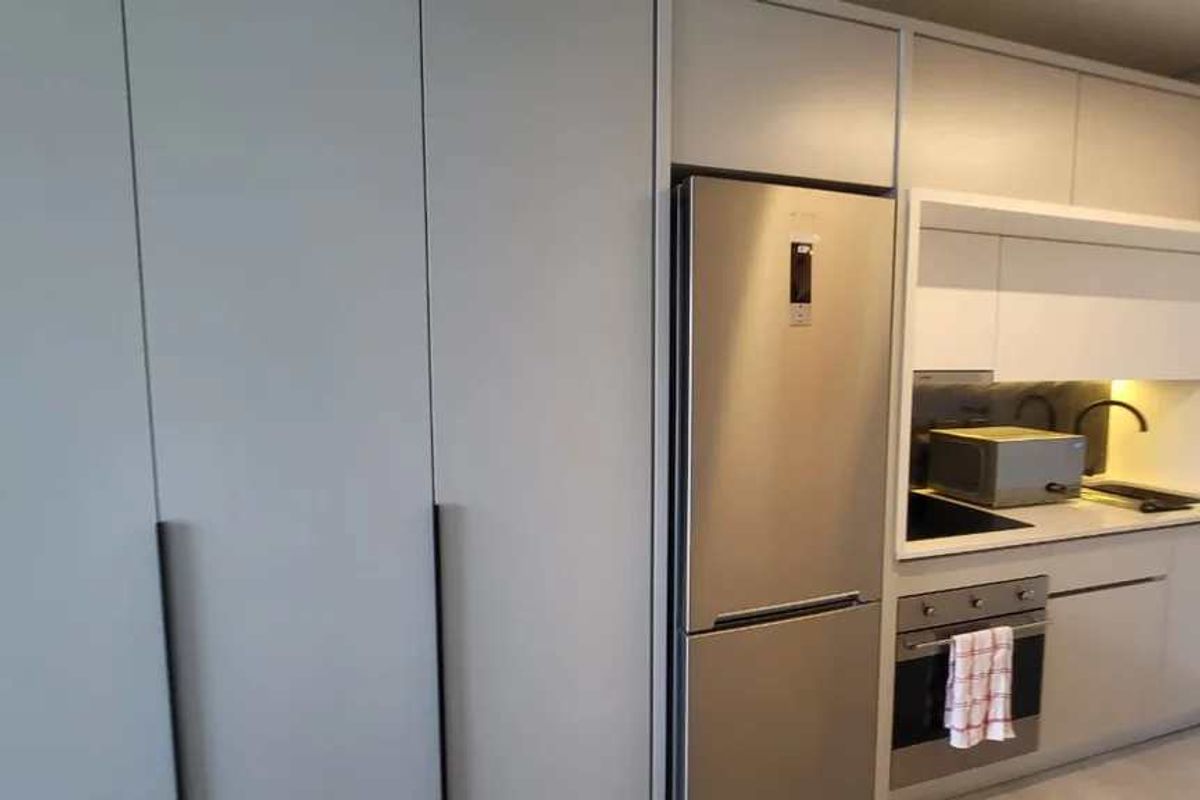 Modern kitchen featuring sleek built-in cabinetry, stainless steel appliances, integrated oven, and a clean, minimalist design with under-cabinet lighting.