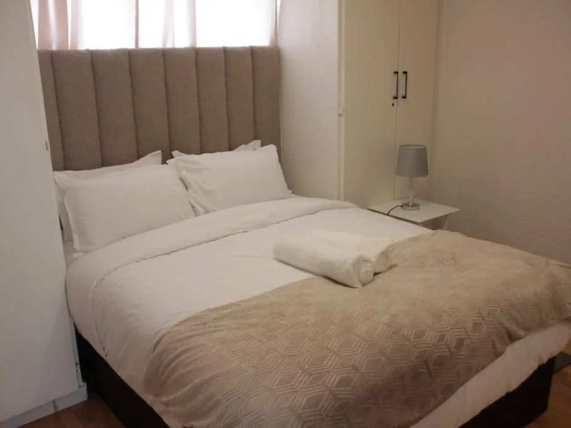 A functional bedroom featuring a built-in wardrobe and neutral finishes, providing a comfortable and practical sleeping space.