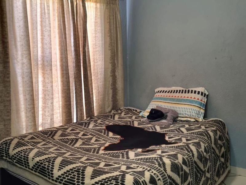 A functional bedroom featuring tiled flooring and coved ceilings, providing a neutral base for personalization.