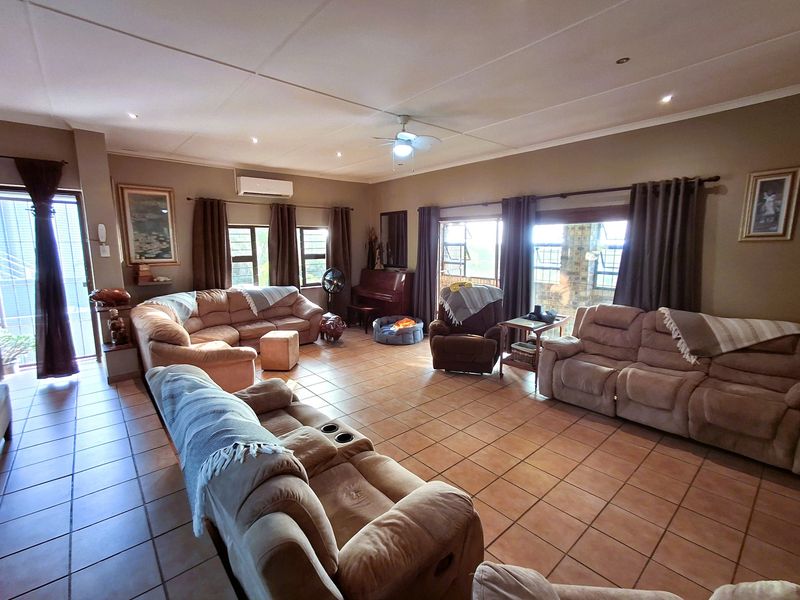 Spacious living room featuring tiled flooring, recessed lighting, a ceiling fan, and split-system air conditioning with access to an outdoor area.