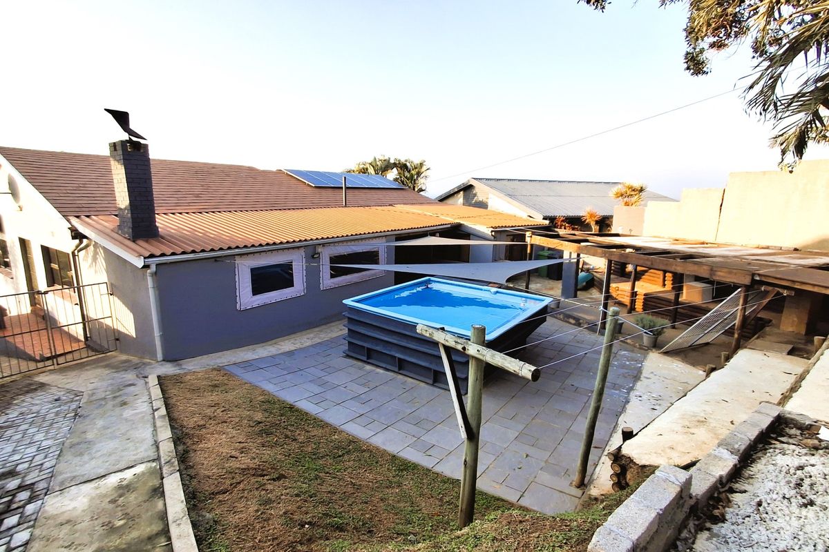 Rear exterior view featuring an above-ground swimming pool, tiled patio area, timber pergola, and solar panels installed on the roof.