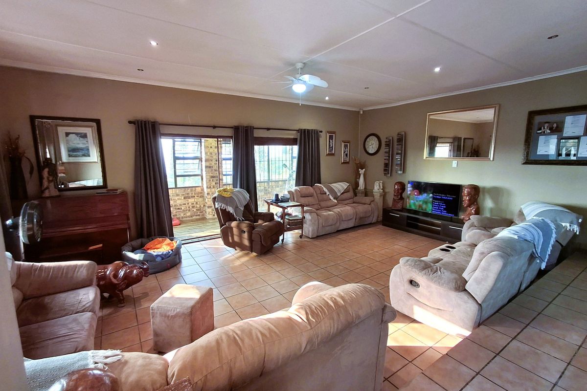 Spacious living room featuring tiled flooring, recessed lighting, a ceiling fan, and large sliding glass doors providing access to the outdoor patio area.